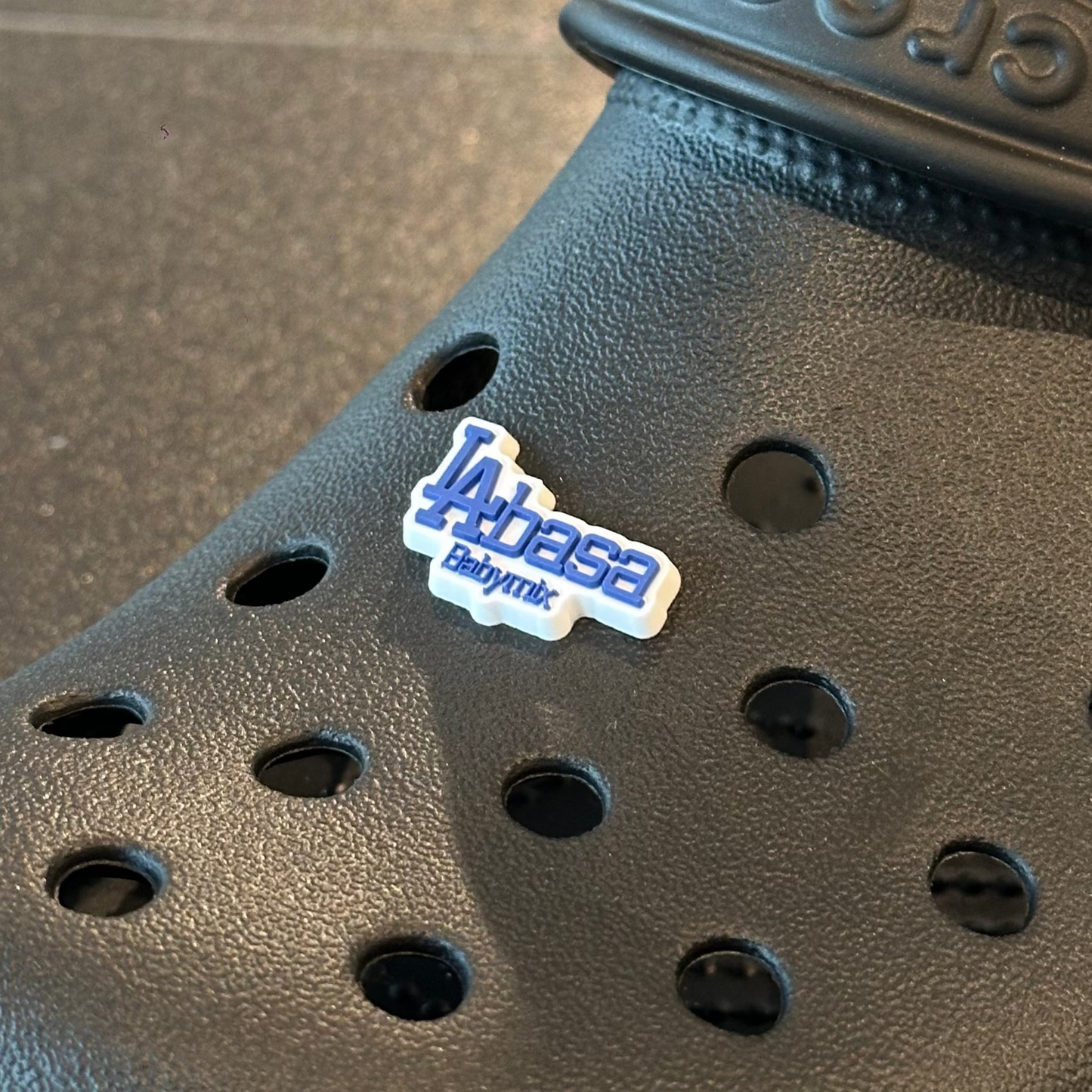 Black Crocs shoe with a visible brand label on a textured surface