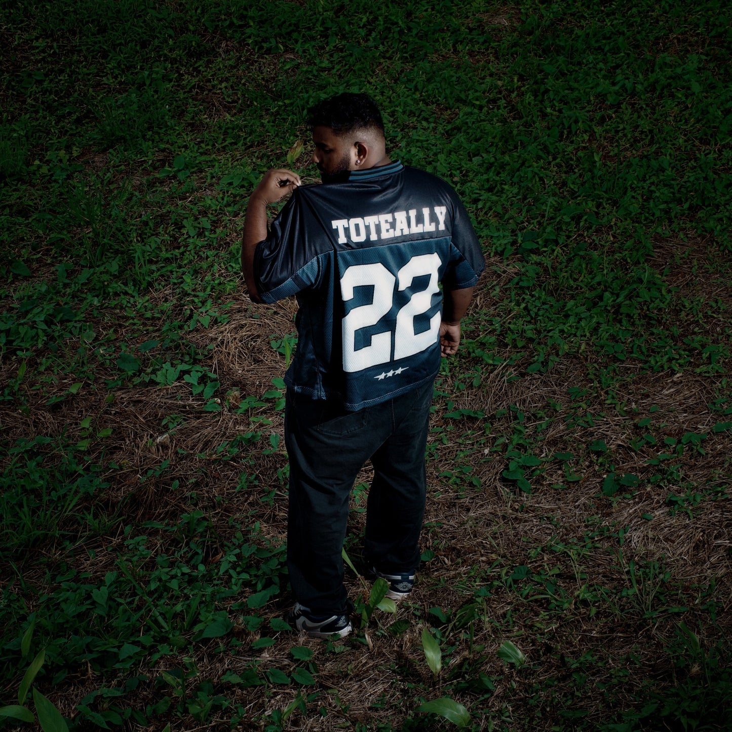 Person wearing a sports jersey with the number 22 on a dark field