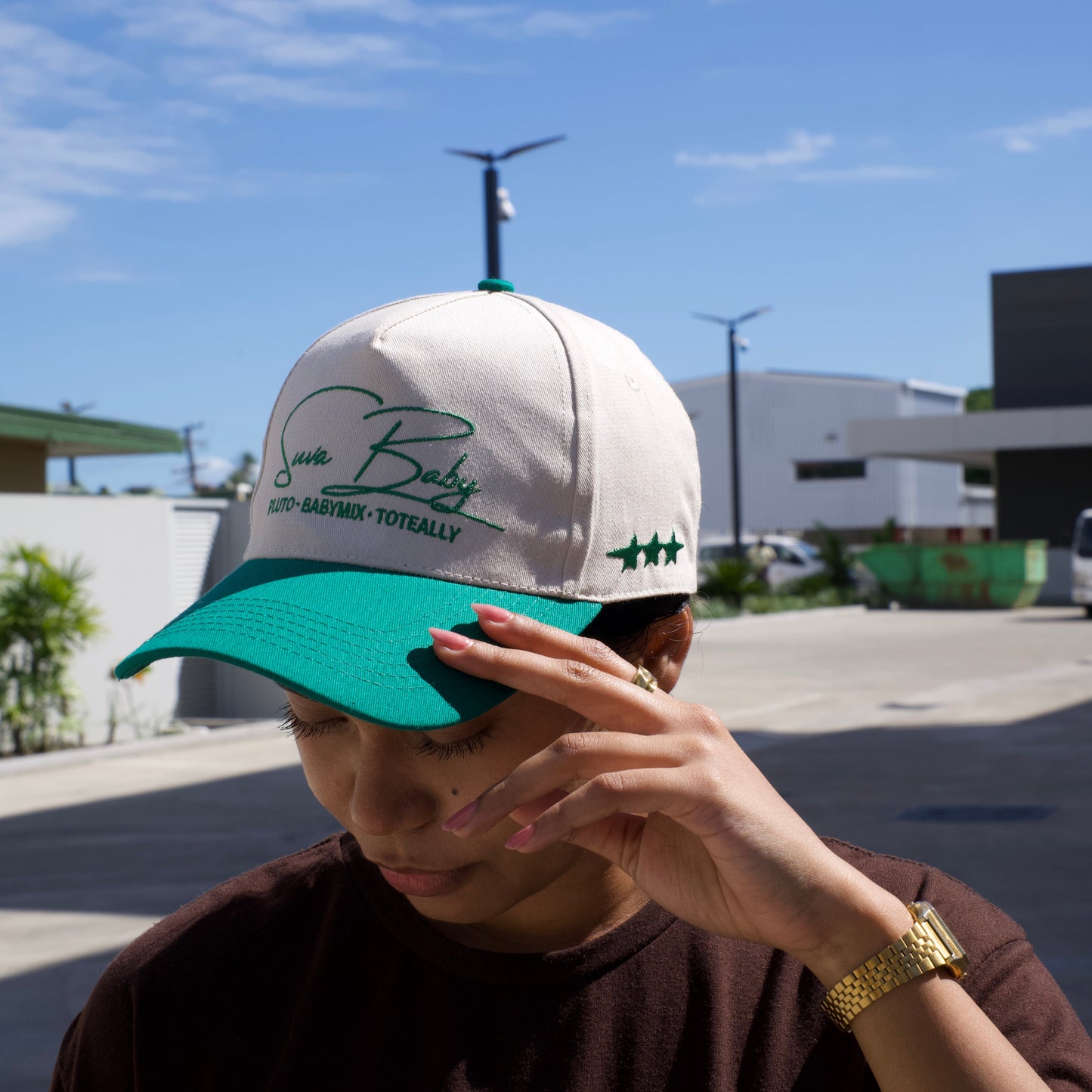 Person wearing a cap with a logo against a blue sky