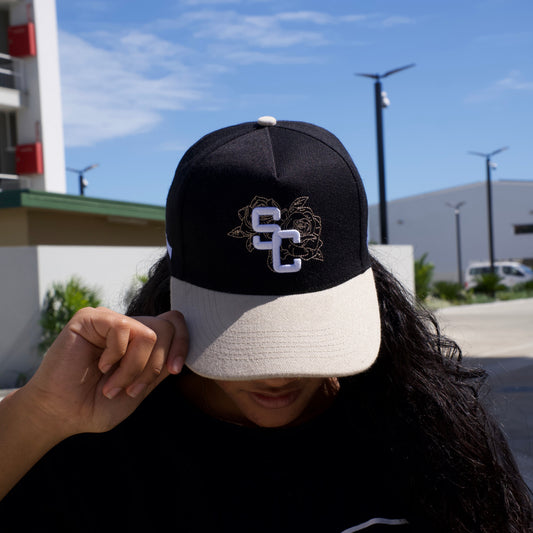 Person wearing a cap with a logo against a blue sky