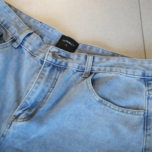 Close-up of blue jeans with a brand label on a light background