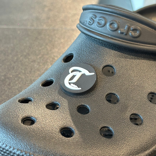 Black Crocs sandal with a logo on a textured surface